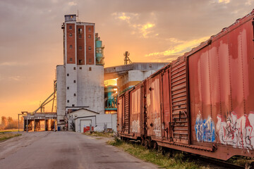 A train with graffiti on it is parked next to a building