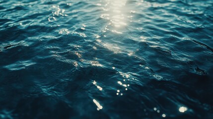 Glittering blue water surface reflecting sunlight in calming shades of blue.