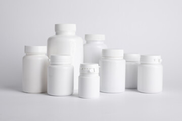 Many plastic medical bottles on white background
