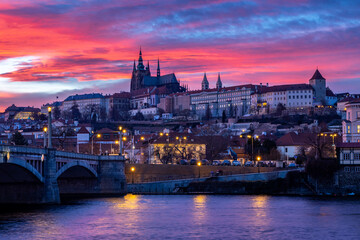 Fiery Sunset Over Historic Prague – A breathtaking sunset, featuring the iconic Prague Castle and Vltava River illuminated by vibrant hues of orange, pink, and purple.