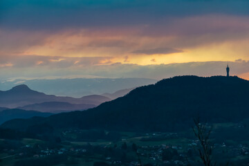 Dramatic sunrise seen from top of Kathreinkogel overlooking Pyramidenkogel and rolling hills of idyllic village Schiefling am See, Carinthia, Austria. Magical atmosphere in remote Austrian Alps