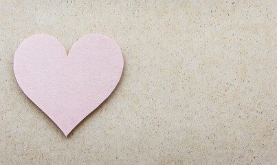 Obraz premium Pink paper heart on beige background.