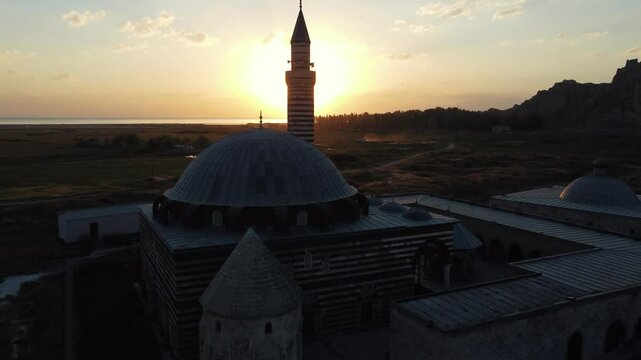 Magnificent view of the Husrev Pasha Mosque and its social complex at sunset on the shores of Lake Van, taken with a drone. A unique combination of history, nature and architecture.