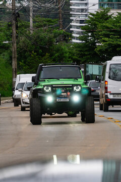 Green modified Troller T4 driving in city traffic, Brazilian off-road 4x4 SUV on the street

