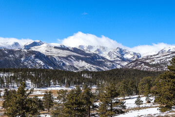 snowy mountain peaks in clouds at rocky mountain 