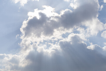 sun rays break through the clouds in the blue sky