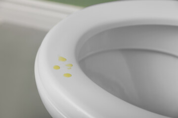 Urine drops on toilet seat in restroom, closeup