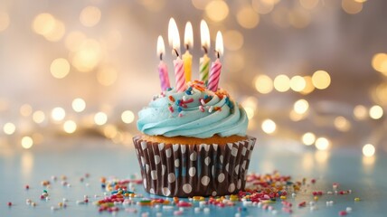 A delicious cupcake topped with blue frosting, festive sprinkles, and five colorful candles, perfect for a birthday celebration.
