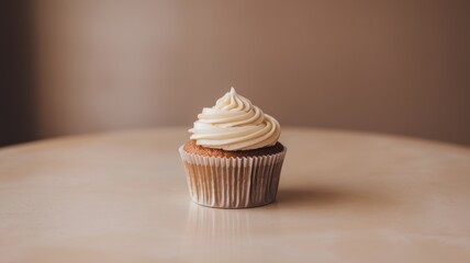 A beautifully decorated vanilla cupcake with creamy frosting on a simple beige table, exuding warmth and sweetness.
