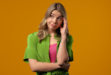 Thinking around stylish woman on yellow background. Puzzled lady looking answer