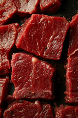 A close up of a piece of raw beef on a black surface