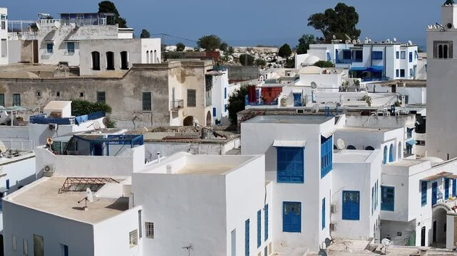 An enchanting drone journey over the rooftops of Sidi Bou Said in Tunisia, capturing its traditional blue and white aesthetics, cobbled streets, and panoramic views of the Mediterranean Sea.