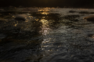 water flowing into the river at sunset
