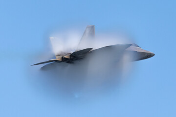 Very unusual close view of a F-22 Raptor at very high speed, with condensation cone...