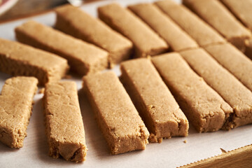 Homemade snack bars made of whey protein powder, ground oat flakes, maple syrup and nut butter