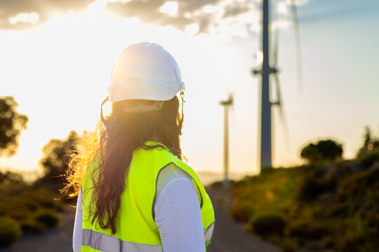 Female engineer observing wind turbines at a wind farm
