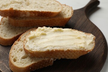 Fresh bread with butter on white table, closeup