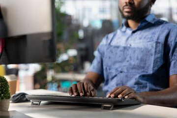 Data scientist typing on keyboard, creating machine learning models that can process and analyze data to improve and automate decision making processes. Close up of man programming in office using PC