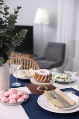 Festive table setting with dishware, desserts and glasses indoors