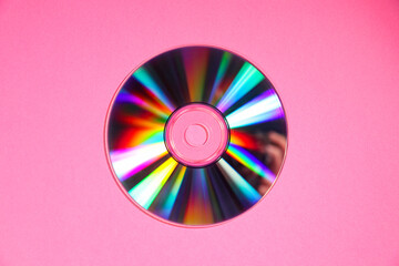 One shiny compact disc on pink background, top view