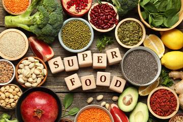 Superfood. Different healthy food products and cubes on wooden table, flat lay
