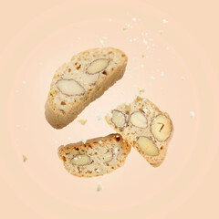 Tasty cookies with almond nuts in air on pink beige background. Traditional Italian Cantuccini