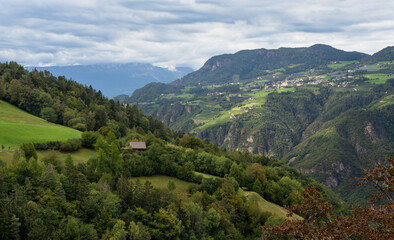 Naklejka premium Beautiful houses and farms dot the hillsides of Tyrollean Italy in the Dolomites.