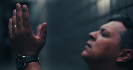 Man praying with hands joined, looking upward, seeking hope and guidance during difficult times, conveying faith, resilience, and emotional struggle in a close-up