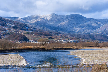 Fototapeta premium 雪化粧の山々と冷たそうな清流