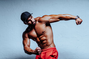 Young strong man bodybuilder portrait on white wall background