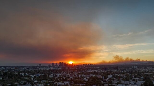Smoke from devastating Pacific Palisades and Hollywood Hills fires cover sky over Los Angeles skyline panorama at sunset. Hyperlapse aerial view, zoom in.