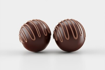 Fototapeta premium Two delicious chocolate truffles with drizzled milk chocolate topping.
