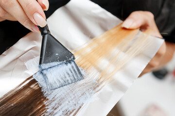 Professional hair coloring of woman in hairdressing salon