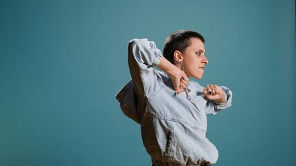 Groovy bold funky woman dancing and fooling around in the studio, acting funny with silly dance moves. Happy confident girl with an urban street style being crazy and edgy. Camera A.