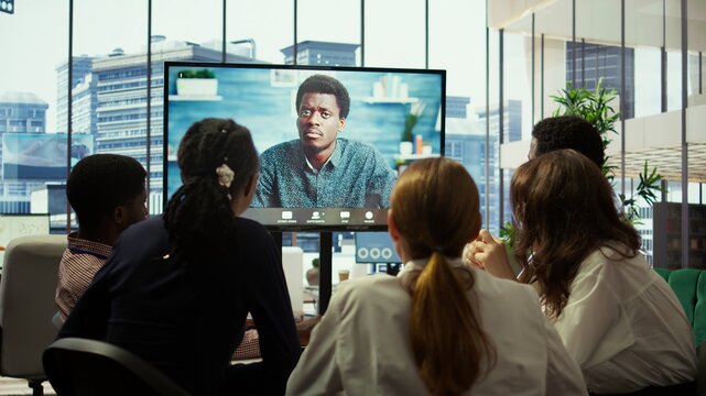 CEO leading a meeting on online teleconference call in the boardroom, discussing about latest updates with his employees. Business experts review financial planning to drive company growth. Camera B.