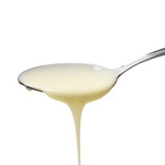 Delicious condensed milk pouring from spoon isolated on white