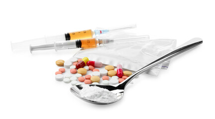 Drug addiction. Different pills, spoon with powder and syringes isolated on white