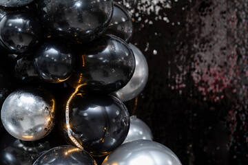 Generated imageLuxurious black and silver balloon arrangement with shimmering sequins and warm fairy lights. A perfect backdrop for elegant parties, New Year's celebrations, and glamorous events.