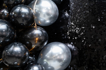 Generated imageLuxurious black and silver balloon arrangement with shimmering sequins and warm fairy lights. A perfect backdrop for elegant parties, New Year's celebrations, and glamorous events.