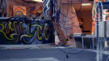 Empty derelict building with creative graffiti street art on walls, concept of alternative lifestyle. Dirty wrecked base of operations used by criminals to commit illegal activities, panning shot