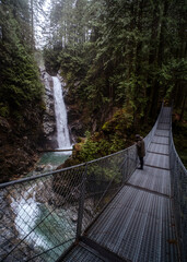 suspension bridge in the forest over a waterfall