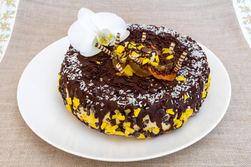 Delicious chocolate cake with tropical fruit and decorative orchid flower