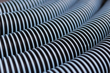 Five black plastic hoses with blue thread texture lined up tightly, close up photo taken from high...