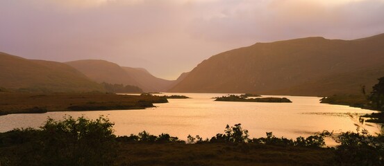 Glenveagh National Park in Donegal Ireland -Spectacular aerial view showcasing lush green valleys and rolling hills beneath a colorful and vibrant sky