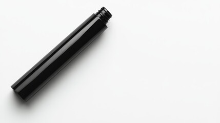 66.A close-up of a matte black cosmetic tube lying horizontally on a white background, with crisp, soft shadows that emphasize its premium design.