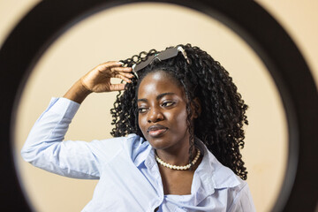 African American influencer student recording content for social media with his phone in a dorm room
