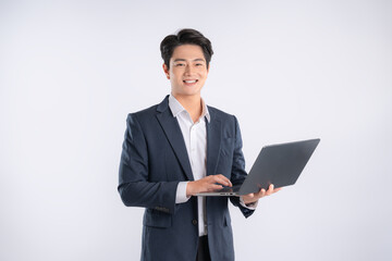 Portrait of young Asian business man using laptop and posing on white background