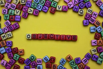 Objective Concept Depicted Using Colorful Letter Cubes on a Yellow Background