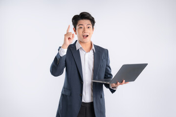 Portrait of young Asian business man using laptop and posing on white background