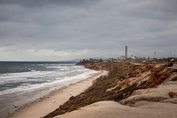 Pacific Ocean coastal landscape with crashing waves and dramatic sky in Carlsbad, Southern California and beach next to scenic HWY1.